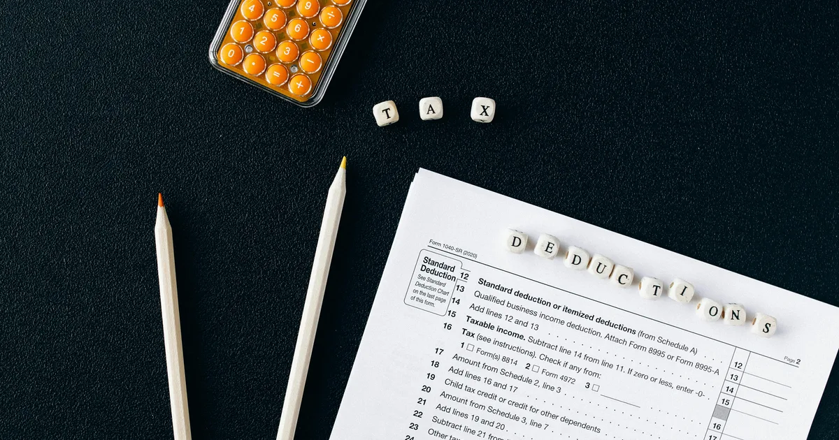 Australian small business owner comparing a bookkeeper engagement letter with a registered BAS agent registration certificate at a desk with a calculator and pencils