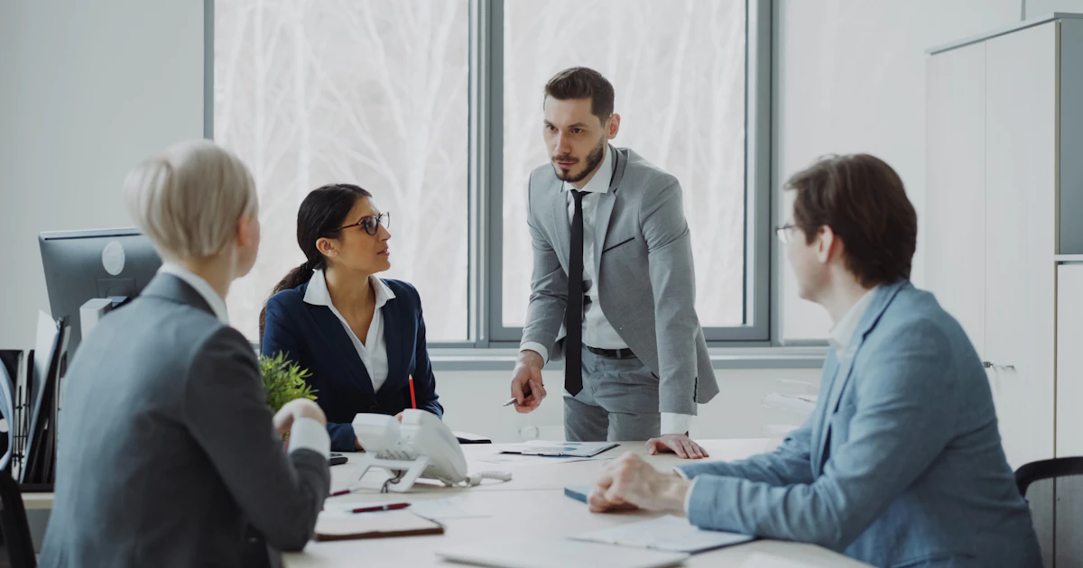 Small business owner meeting with a bookkeeper candidate across a desk, reviewing financial documents