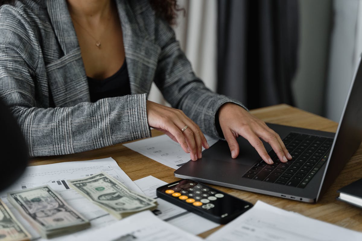 Australian bookkeeper working at a laptop with calculator, receipts, and Xero open on the screen