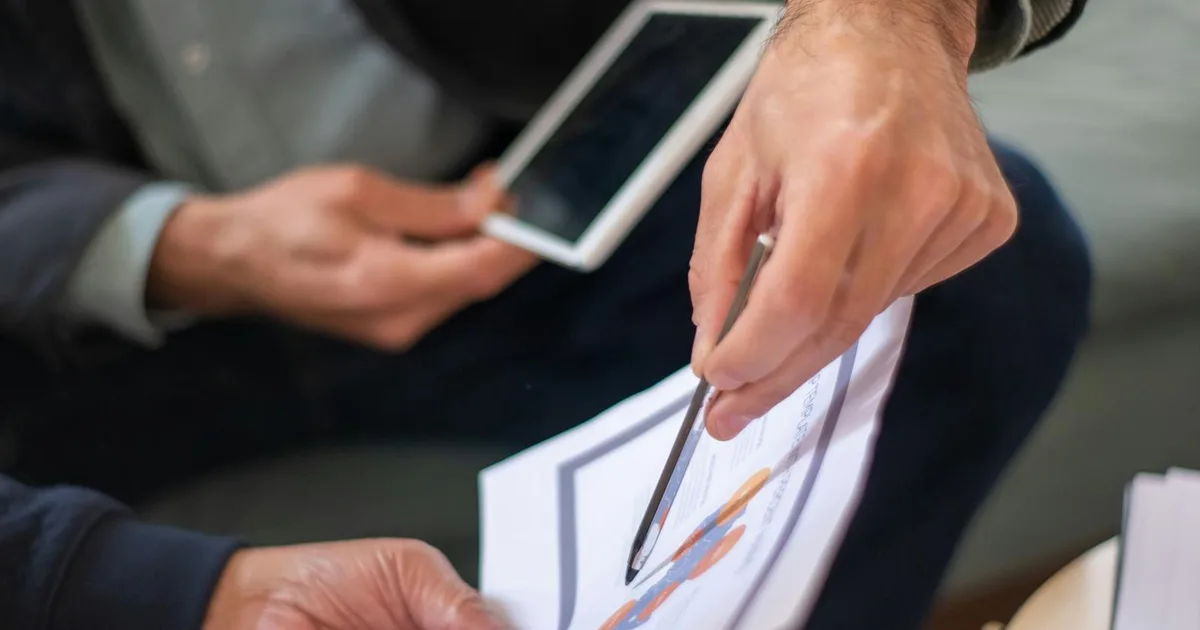 Australian small business owner meeting with a bookkeeper and accountant to review financial documents at a desk